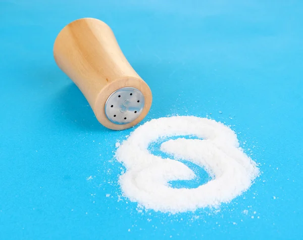 Wooden salt shaker on green background — Stock Photo, Image