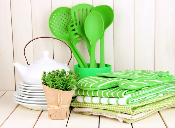 Kitchen settings: utensil, potholders, towels and else on wooden table — Stock Photo, Image