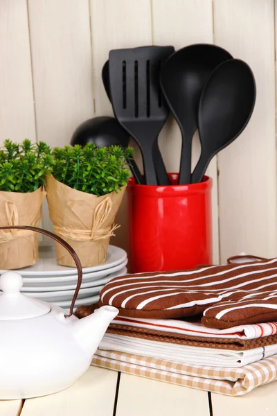 Configurações da cozinha: utensílio, pegadores de panela, toalhas e muito mais na mesa de madeira — Fotografia de Stock