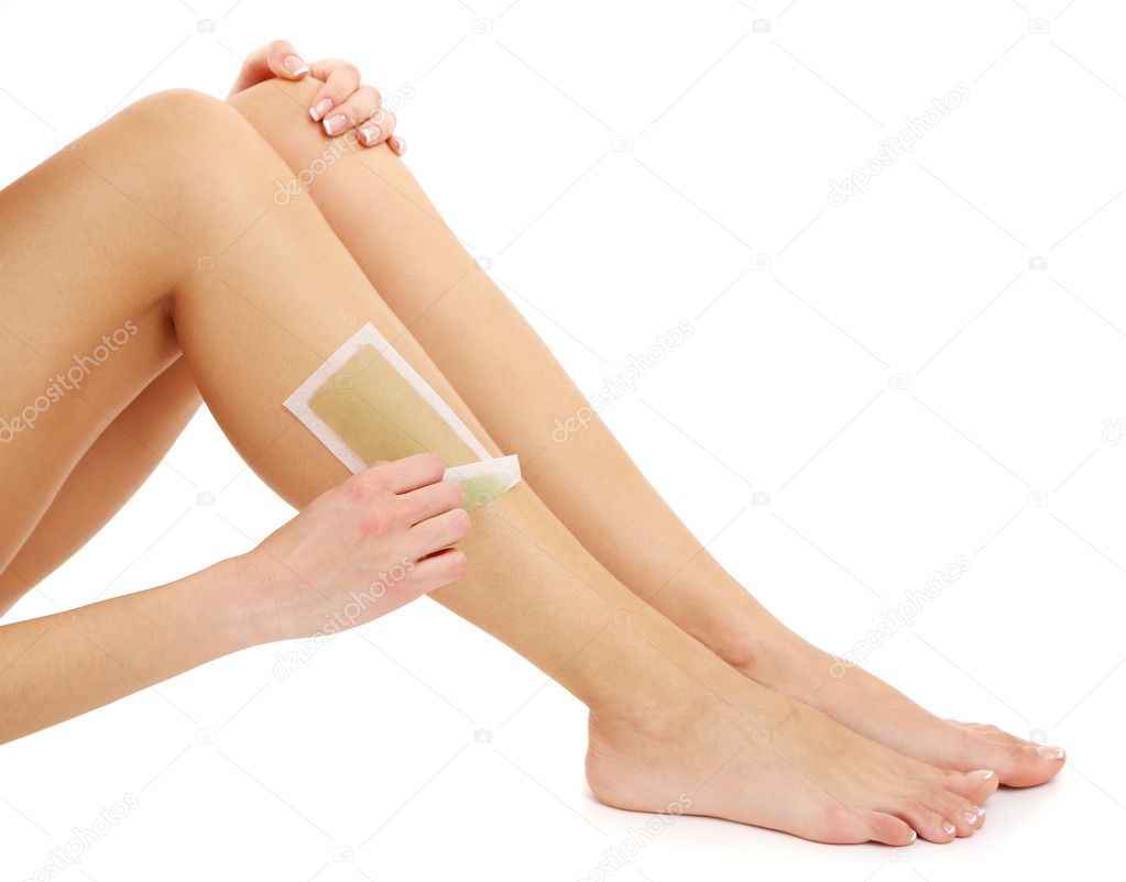 Beautiful woman doing depilation for her legs with waxing, isolated on white