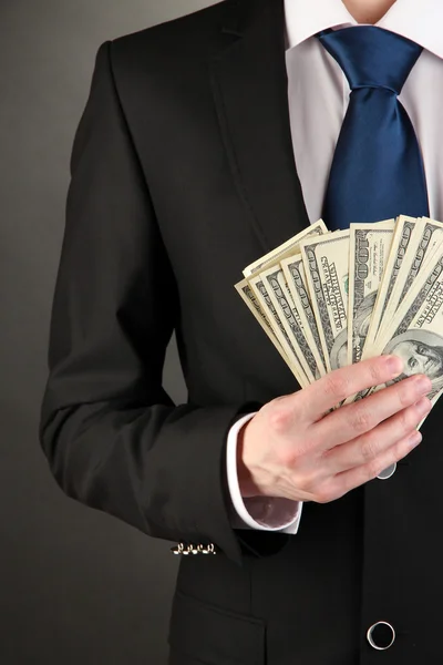 Business man holds lot of money on black background — Stock Photo, Image