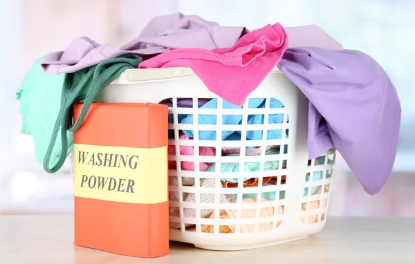 Clothes in plastic basket on table in room — Stock Photo, Image