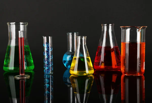 Test tubes with colorful liquids on dark grey background — Stock Photo, Image