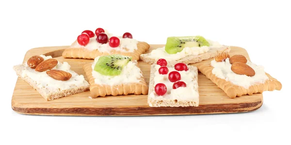 Lekkere canapeetjes met kaas, kiwi en cranberry, almond, op snijplank, geïsoleerd op wit — Stockfoto