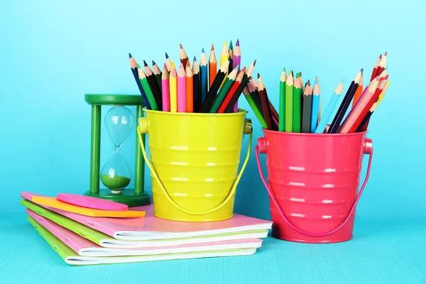 Lápices de colores con útiles escolares sobre fondo azul —  Fotos de Stock