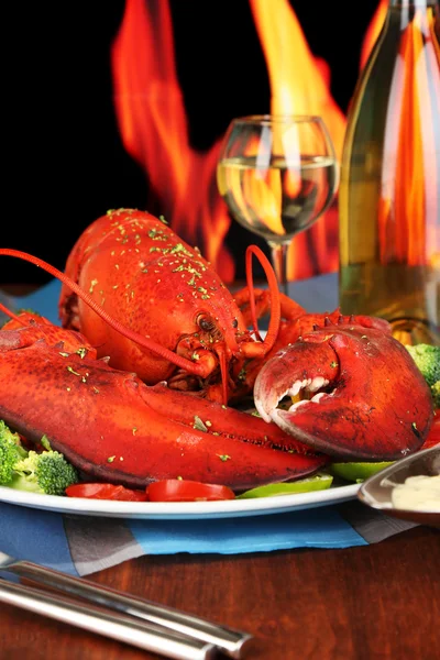 Langosta roja en bandeja sobre mesa de madera sobre fondo de fuego — Foto de Stock