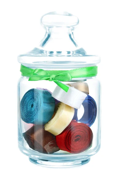 Glass jar containing various colored ribbons isolated on white — Stock Photo, Image