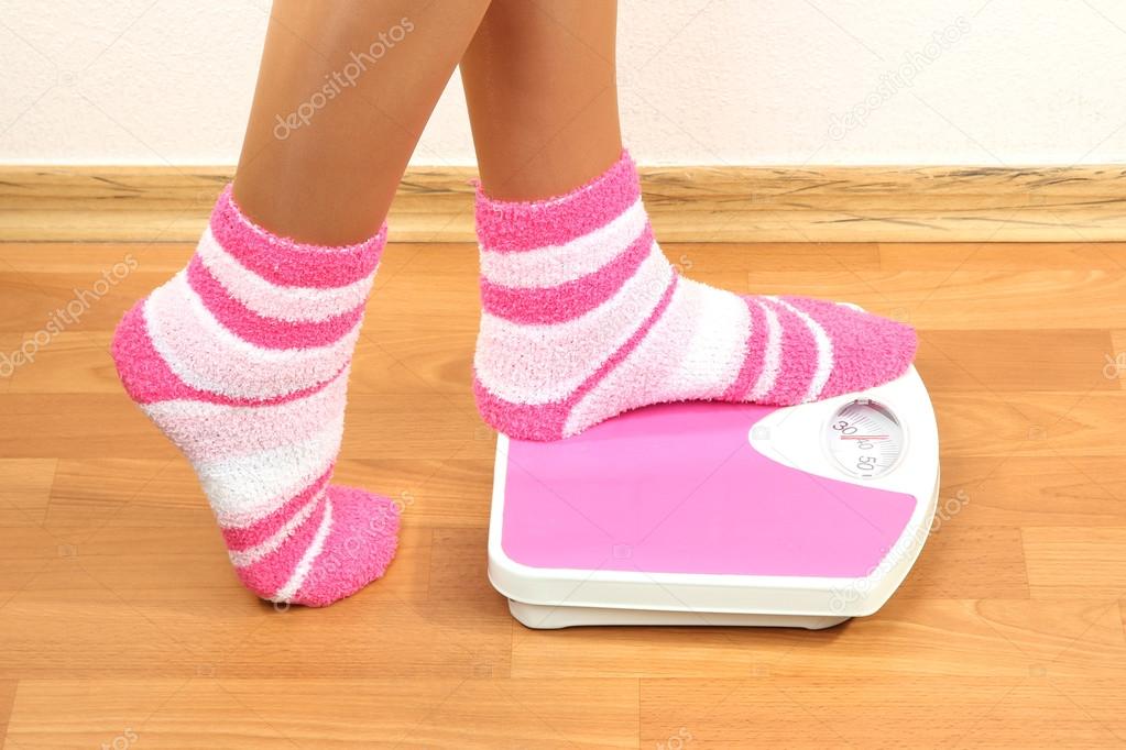 Feet on scales on floor in room