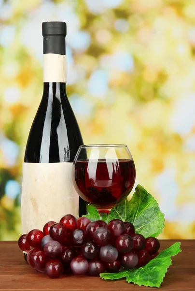 Composition of wine bottle, glass and grape, on bright background — Stock Photo, Image