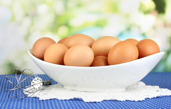Eggs in white bowl on blue tablecloth close-up — Stock Photo, Image
