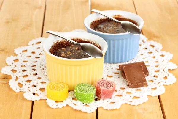 Budyń czekoladowy w miski do pieczenia na drewnianym stole — Zdjęcie stockowe