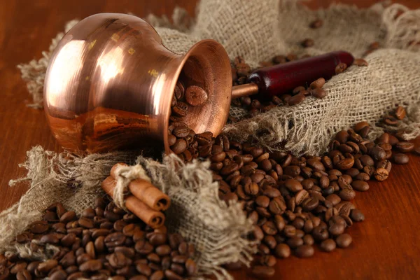 Cafetera con granos de café sobre fondo de madera marrón — Foto de Stock