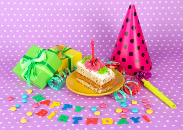 Bunte Geburtstagstorte mit Kerze und Geschenken auf rosa Hintergrund — Stockfoto