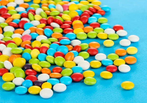 Kolorowe cukierki na niebieskim tle — Zdjęcie stockowe