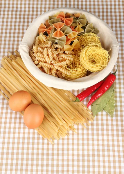 Verschiedene Arten von Pasta auf kariertem Hintergrund — Stockfoto