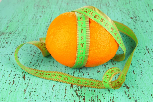 Oranžová s měřicí pásku, na barevné dřevěné pozadí — Stock fotografie