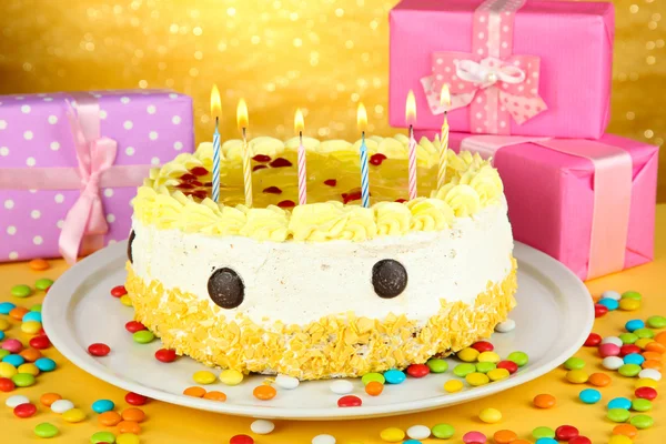 Happy birthday cake and gifts, on yellow background — Stock Photo, Image