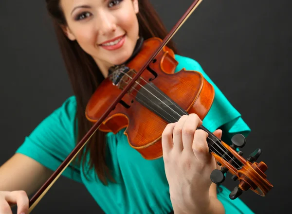 Όμορφη νεαρή κοπέλα με το βιολί σε γκρι φόντο — Φωτογραφία Αρχείου