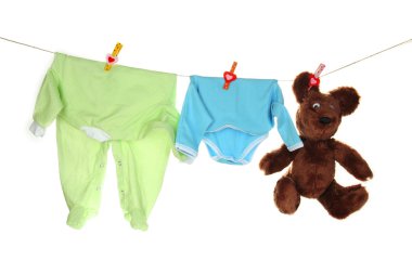 Bebek giysileri üzerinde beyaz izole clothesline üzerinde asılı