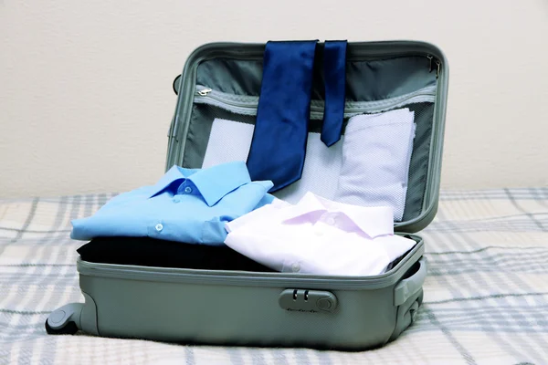 Buka koper abu-abu dengan pakaian di tempat tidur — Stok Foto