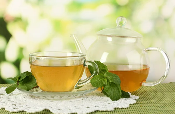 Tasse de thé à la menthe sur table sur fond de bacs lumineux — Photo