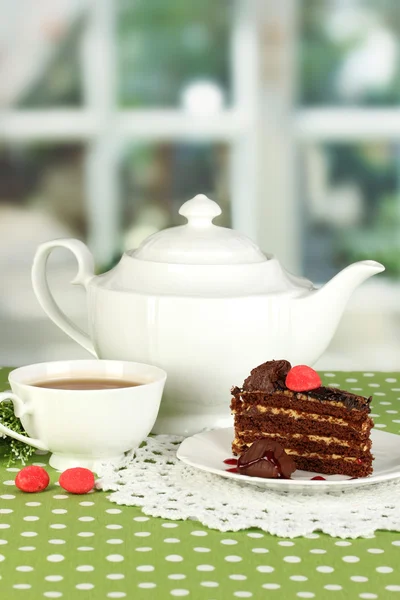 Tetera, taza de té y delicioso pastel en el fondo de la ventana — Foto de Stock