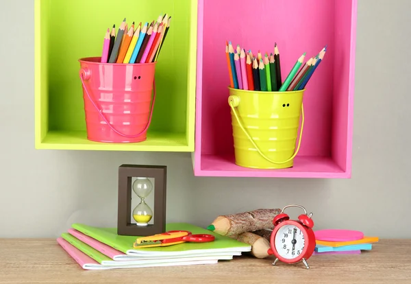 Lápis coloridos em pails em prateleiras no fundo bege — Fotografia de Stock