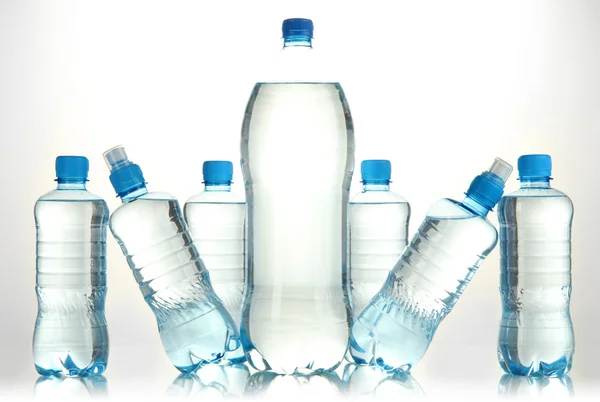 Diferentes botellas de agua aisladas en blanco — Foto de Stock