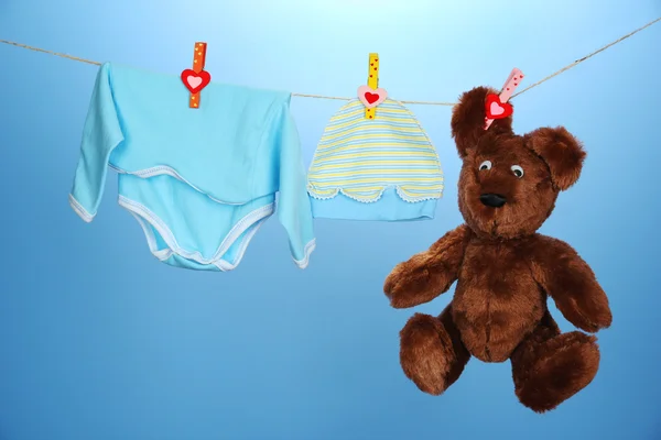 Clothesline üzerinde mavi arka plan asılı bebek giysileri — Stok fotoğraf