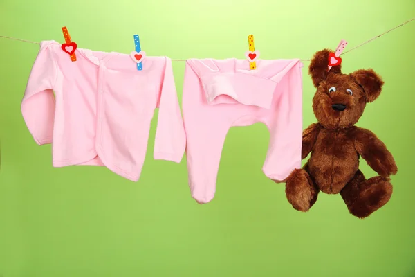 婴儿衣服挂在晾衣绳上颜色背景 — 图库照片