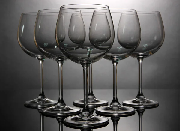 Bicchieri da vino vuoti disposti su sfondo grigio — Foto Stock
