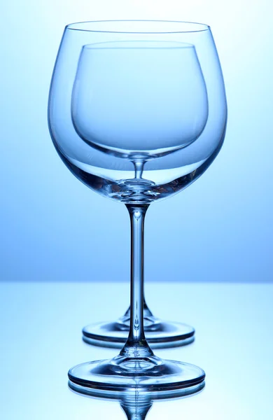 Empty wine glasses arranged on blue background — Stock Photo, Image