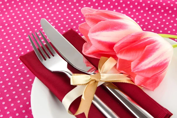 Festive dining table setting with tulips on pink polka-dot background — Stock Photo, Image