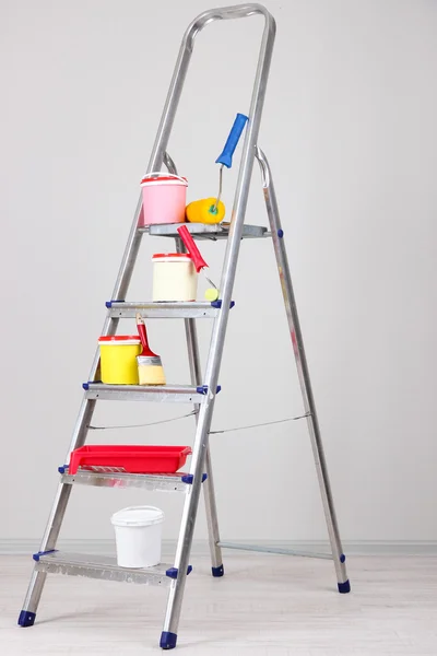 Metalen ladder en verf in kamer — Stockfoto