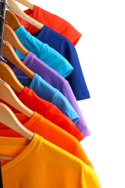 Lots of T-shirts on hangers isolated on white — Stock Photo, Image