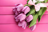Картина, постер, плакат, фотообои "beautiful bouquet of purple tulips on pink wooden background", артикул 22528775