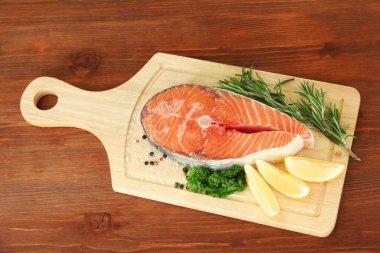 ahşap zemin üzerinde kesme tahtası üzerinde taze somon steak