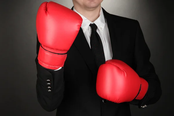 Бизнесмен в боксёрских перчатках на сером фоне — стоковое фото
