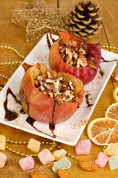 Manzanas al horno en plato sobre mesa de madera —  Fotos de Stock