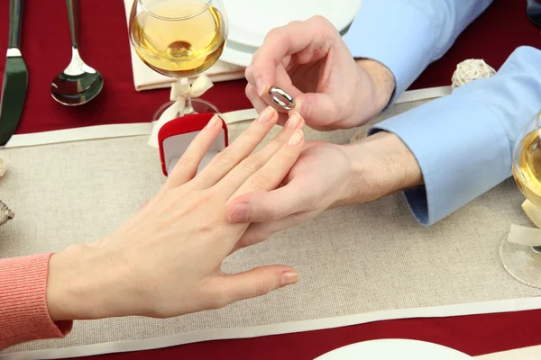 Un homme proposant et tenant une bague de fiançailles sur la table du restaurant — Photo