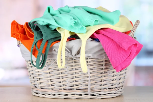 Vêtements dans le panier en bois sur la table dans la chambre — Photo