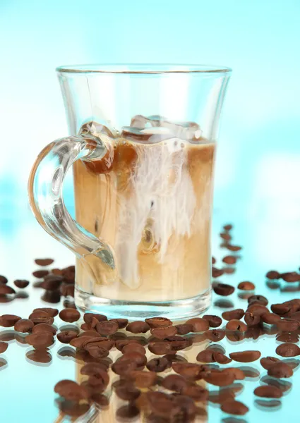 Kalter Kaffee mit Eis im Glas auf blauem Hintergrund — Stockfoto