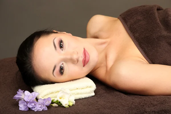 Hermosa joven en el salón de spa, sobre fondo oscuro — Foto de Stock