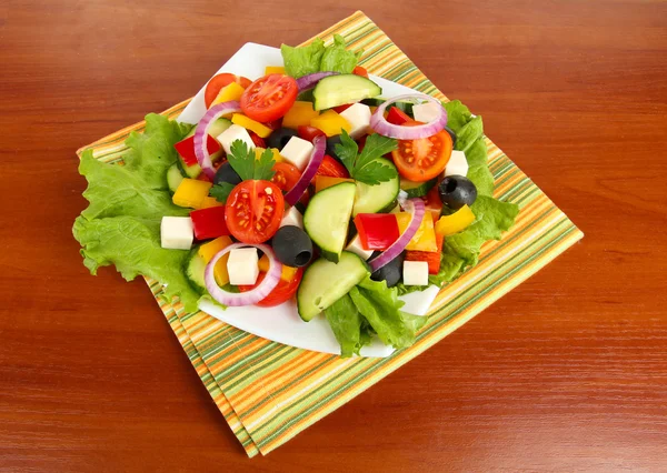 Välsmakande grekisk sallad på trä bakgrund — Stockfoto