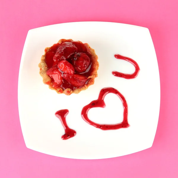 Süße Torte mit Erdbeere und Soße auf Teller, auf farbigem Hintergrund — Stockfoto