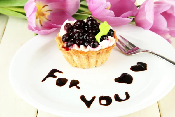 Sladký dort s blackberry a čokoládovou omáčkou na desku, na dřevěné pozadí — Stock fotografie