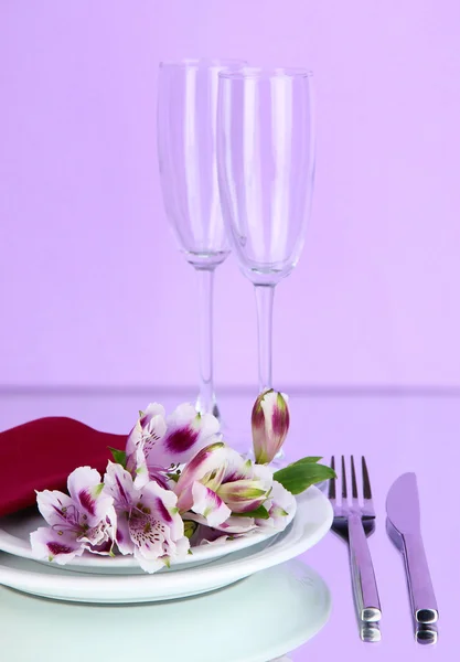 Cenário de mesa festiva com flores em fundo lilás — Fotografia de Stock