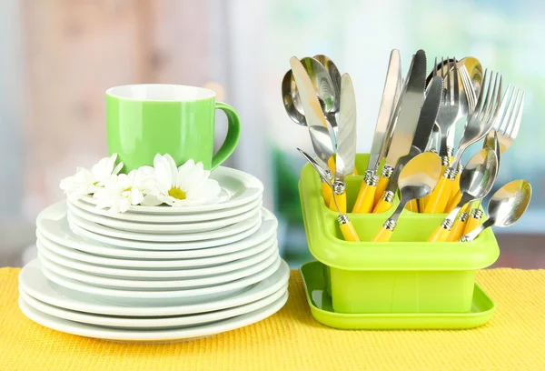 Plaques, fourchettes, couteaux, cuillères et autres ustensiles de cuisine sur serviette de couleur, sur fond lumineux — Photo