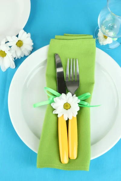 Faca e garfo envolto em guardanapo, na placa, na cor de fundo de toalha de mesa — Fotografia de Stock