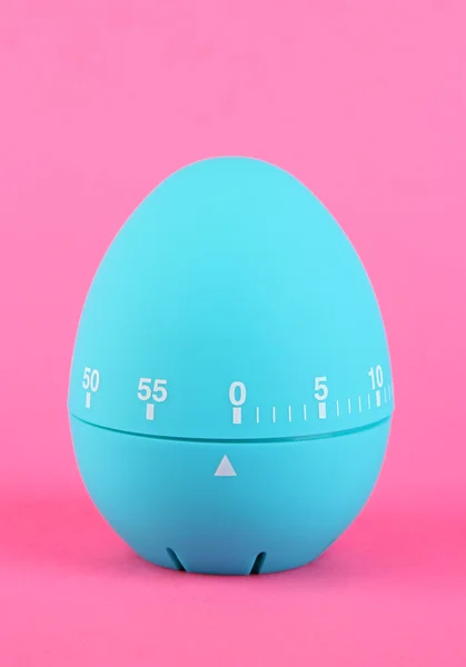 Таймер на голубом яйце, на цветном фоне — стоковое фото